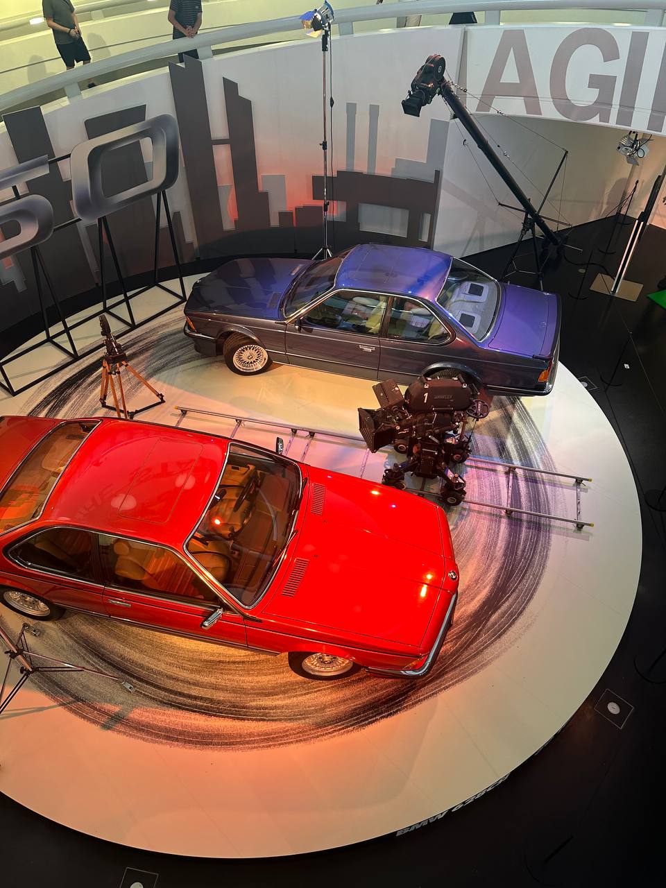 Classic BMW coupes displayed in a film-themed museum exhibition.