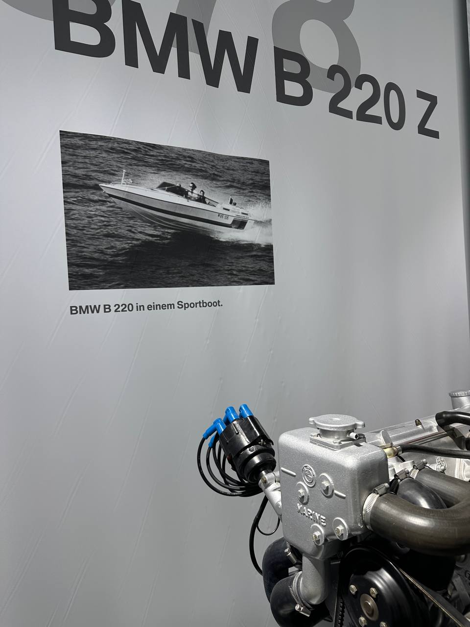 A sleek BMW display car inside BMW Welt with dramatic showroom lighting.