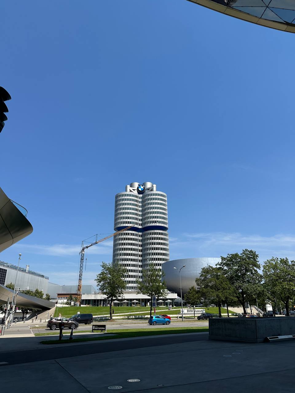 The BMW four-cylinder headquarters tower and museum complex under a clear blue sky.