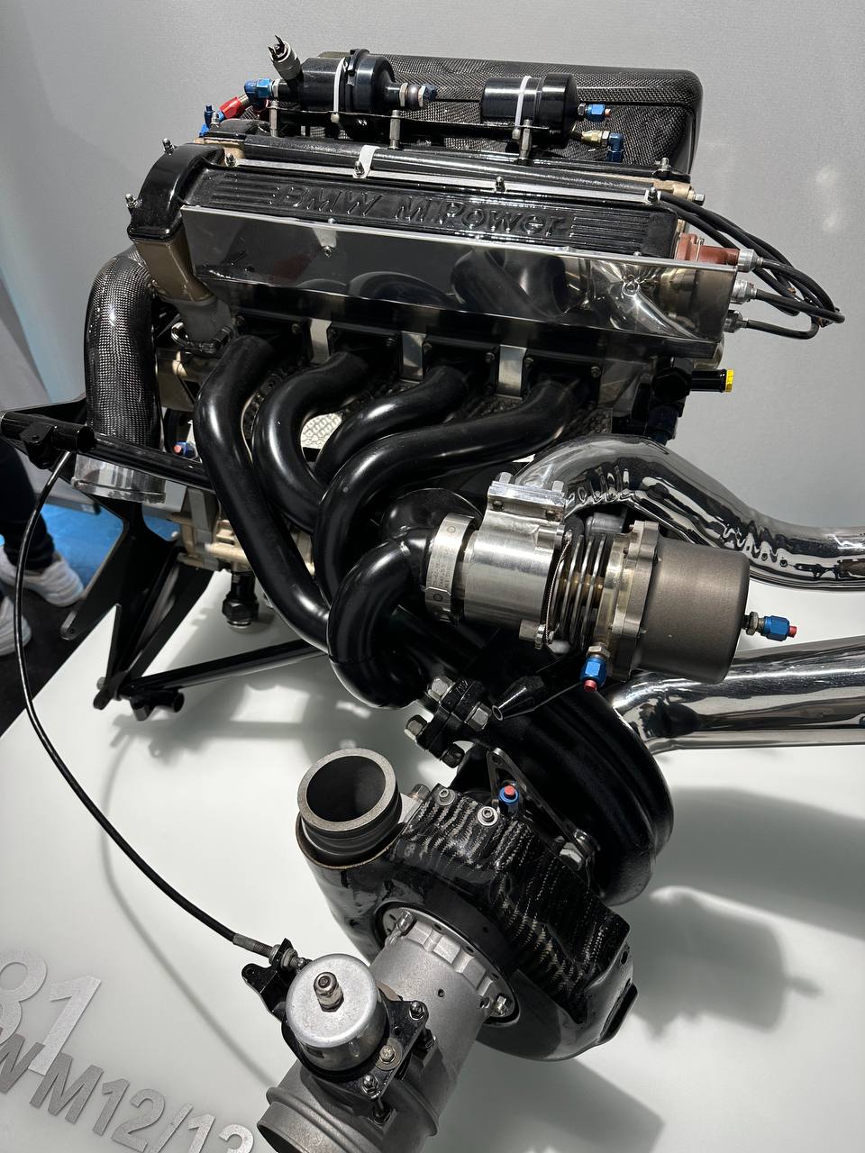 A close-up of a classic BMW M Power racing engine on display.