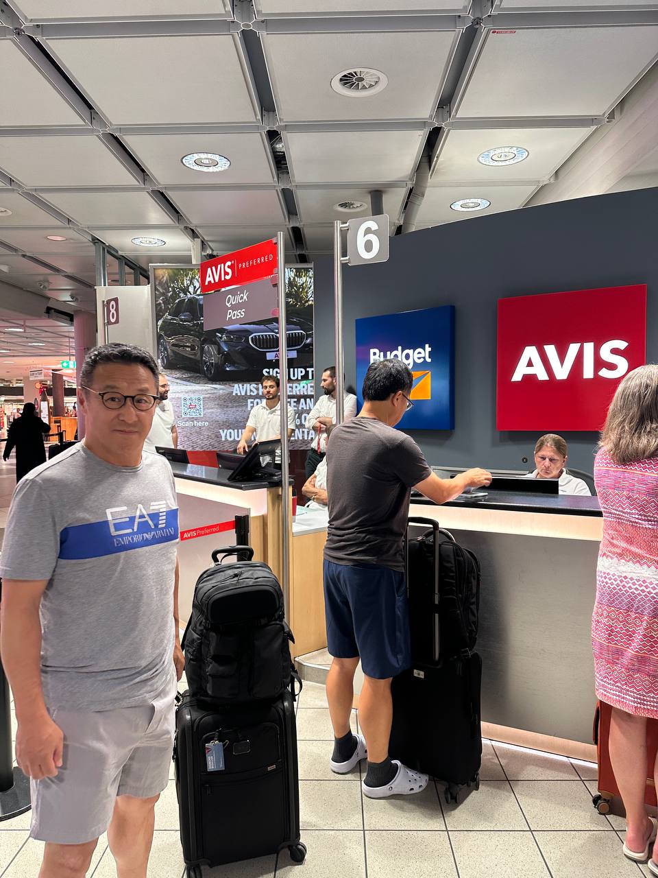 Picking up the rental car at the Avis/Budget counter with our luggage.