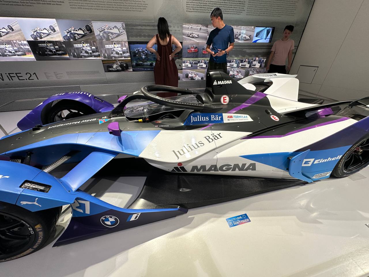A modern BMW Formula E race car displayed in the motorsport section.