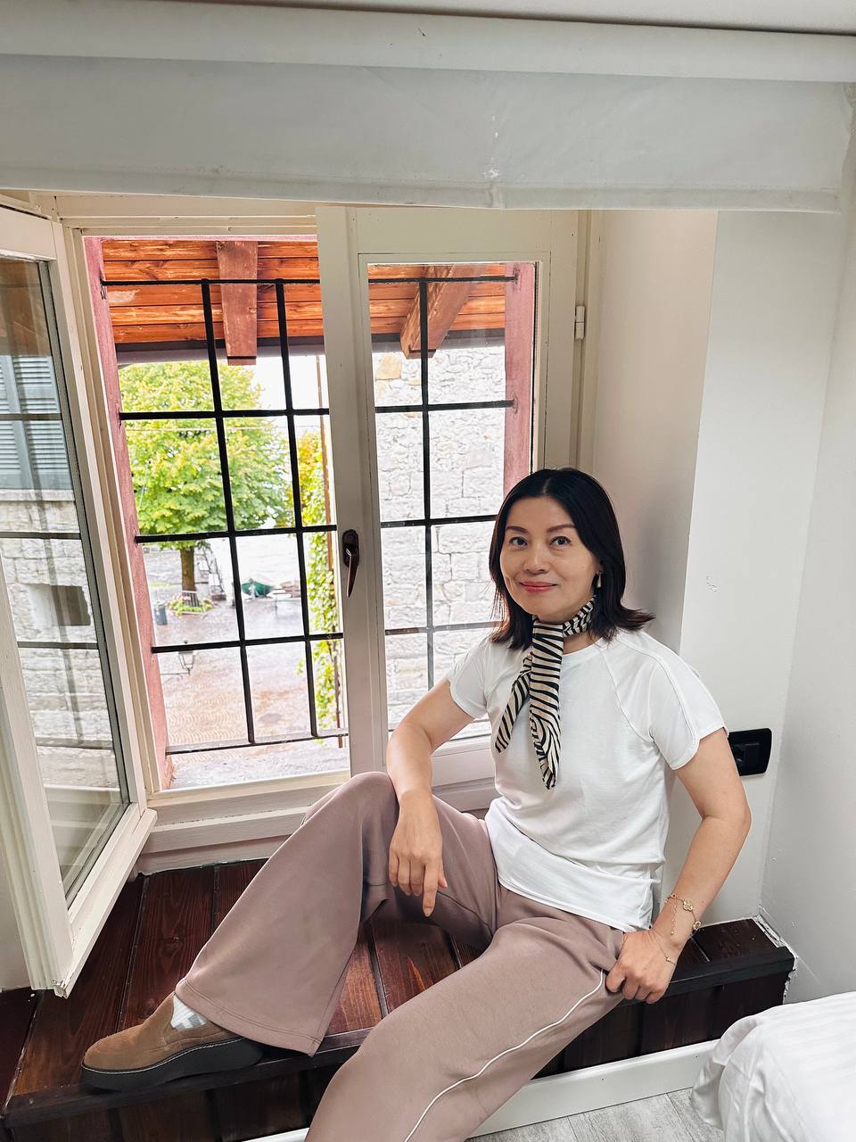 Locanda Alberti 的窗台：Jing 坐在老石墙的窗前。